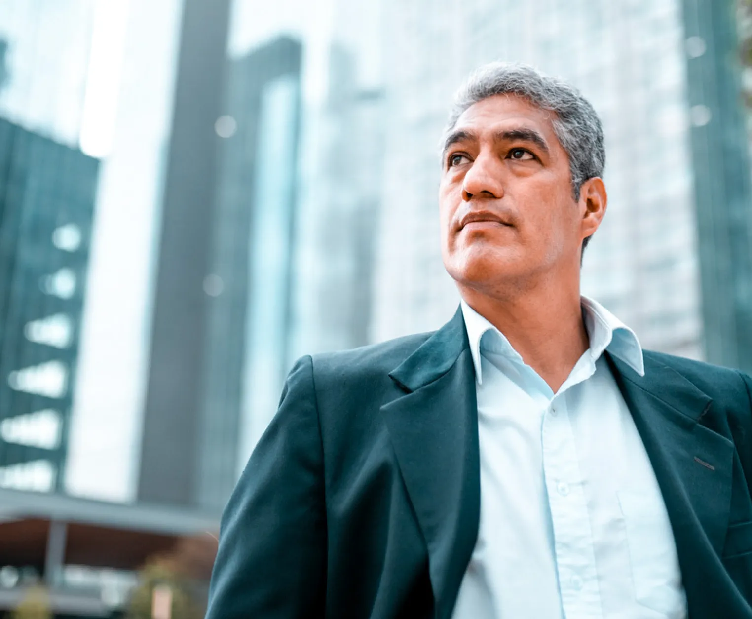 Man standing in a city wearing business attire.